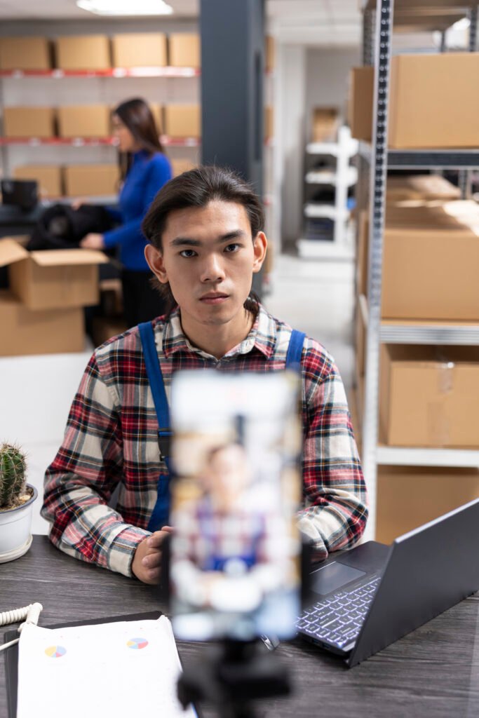 Small business owner uses a smartphone to film content inside fulfillment center
